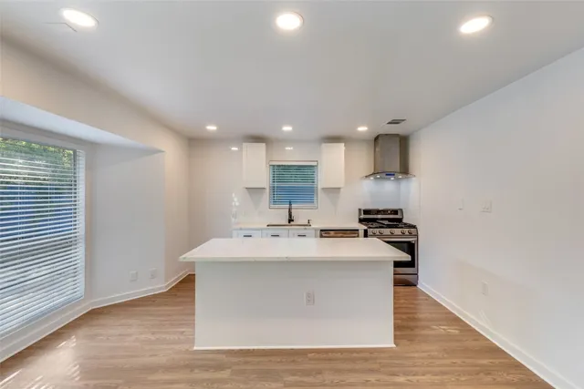 a kitchen with a stove and a wooden floors