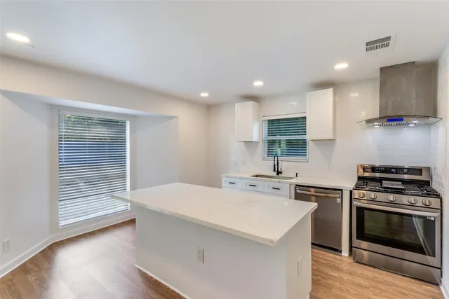 a kitchen with a sink a stove a refrigerator and cabinets