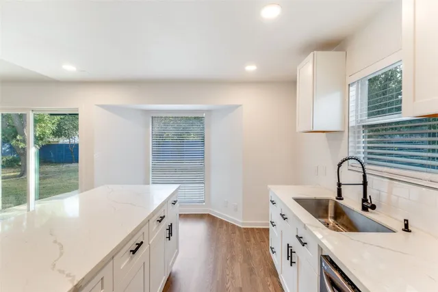 a kitchen with granite countertop white cabinets and white appliances