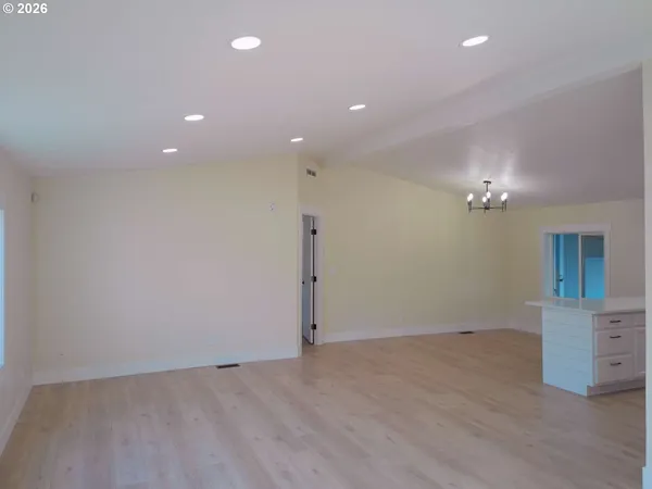 a view of a kitchen with a sink wooden cabinets and glass door