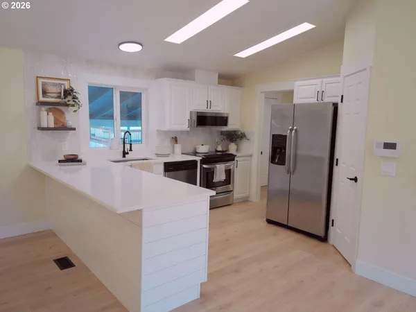 a kitchen with stainless steel appliances a refrigerator stove microwave and cabinets