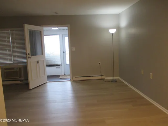 an empty room with wooden floor and a fireplace