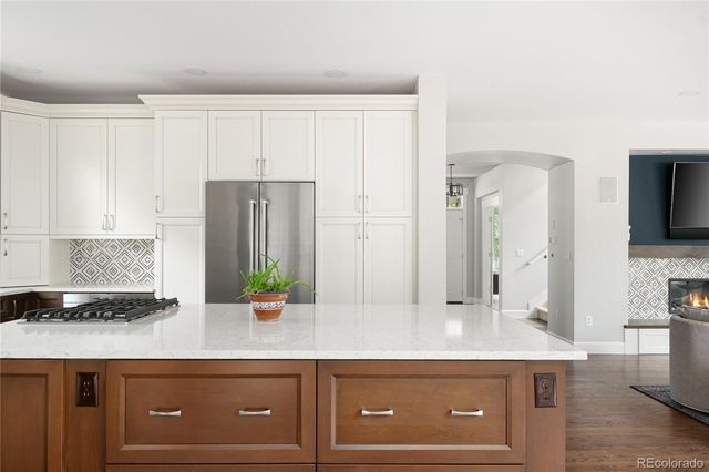 a kitchen with stainless steel appliances granite countertop a refrigerator a stove and a sink