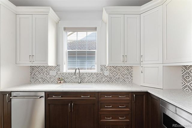a kitchen with granite countertop cabinets sink and window