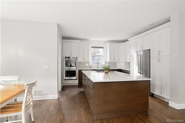 a large kitchen with a center island appliances and cabinets