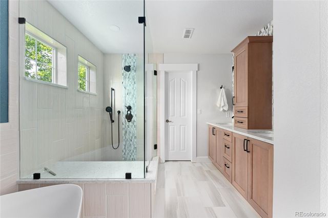 a bathroom with a bathtub sink mirror and shower