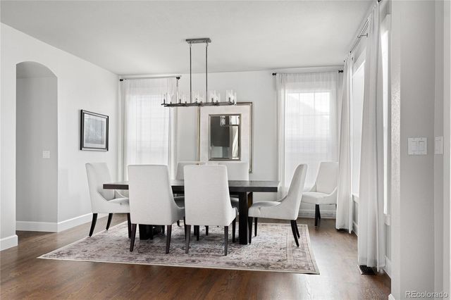a dining room with furniture a chandelier and wooden floor