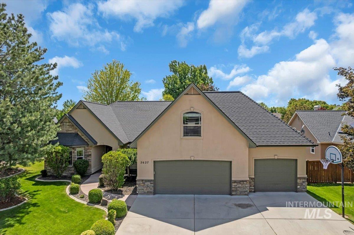2627 East Moog Street Meridian, ID 83646 - Photo 1 of 1 View of front facade featuring stone siding, concrete driveway, stucco siding, a shingled roof, and an attached garage