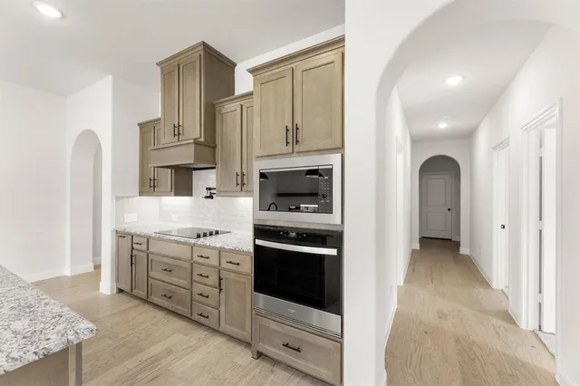 a kitchen with stainless steel appliances granite countertop a stove and a refrigerator