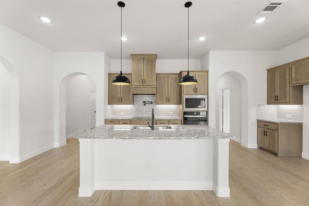 733 Wine Cup Way Midlothian, TX 76065 - Photo 2 of 30 a kitchen with kitchen island a counter top space a sink stainless steel appliances and cabinets