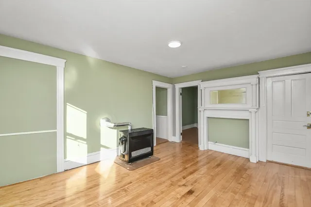 a view of empty room with a fireplace and wooden floor
