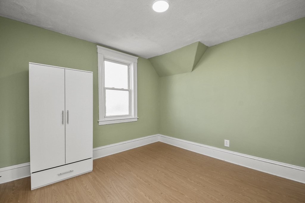 23 Ashton Street Worcester, MA 01605 - Photo 24 of 41 an empty room with wooden floor and windows