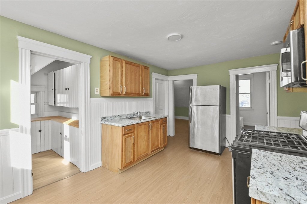 23 Ashton Street Worcester, MA 01605 - Photo 28 of 41 a kitchen with stainless steel appliances granite countertop a refrigerator and a stove top oven