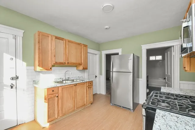 a kitchen with stainless steel appliances granite countertop a refrigerator and a stove