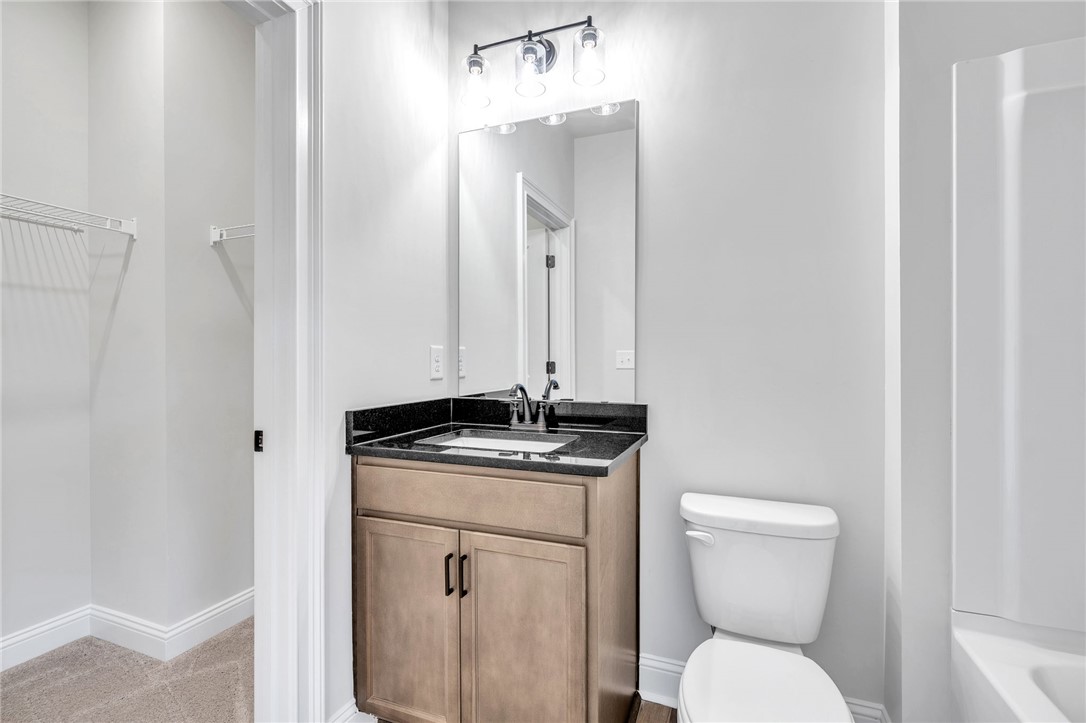 226 Holly Br Road Piedmont, SC 29673 - Photo 35 of 44 A well-appointed bathroom features a dark granite-topped vanity and a clean, functional design.