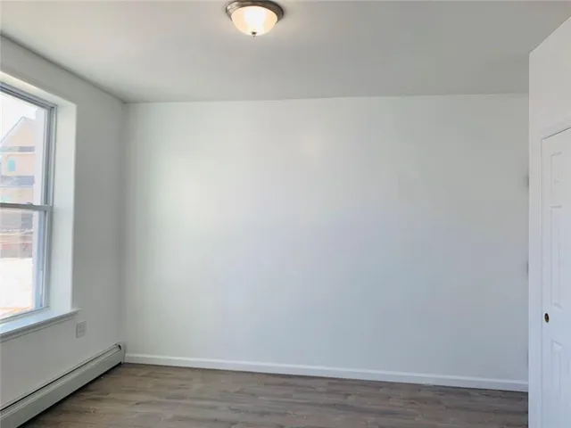 a view of a small space with wooden floor and a window