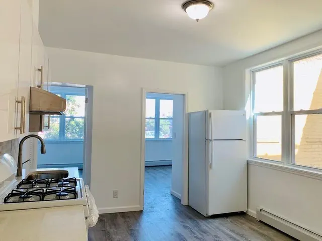 a kitchen with a refrigerator a stove a sink and a window