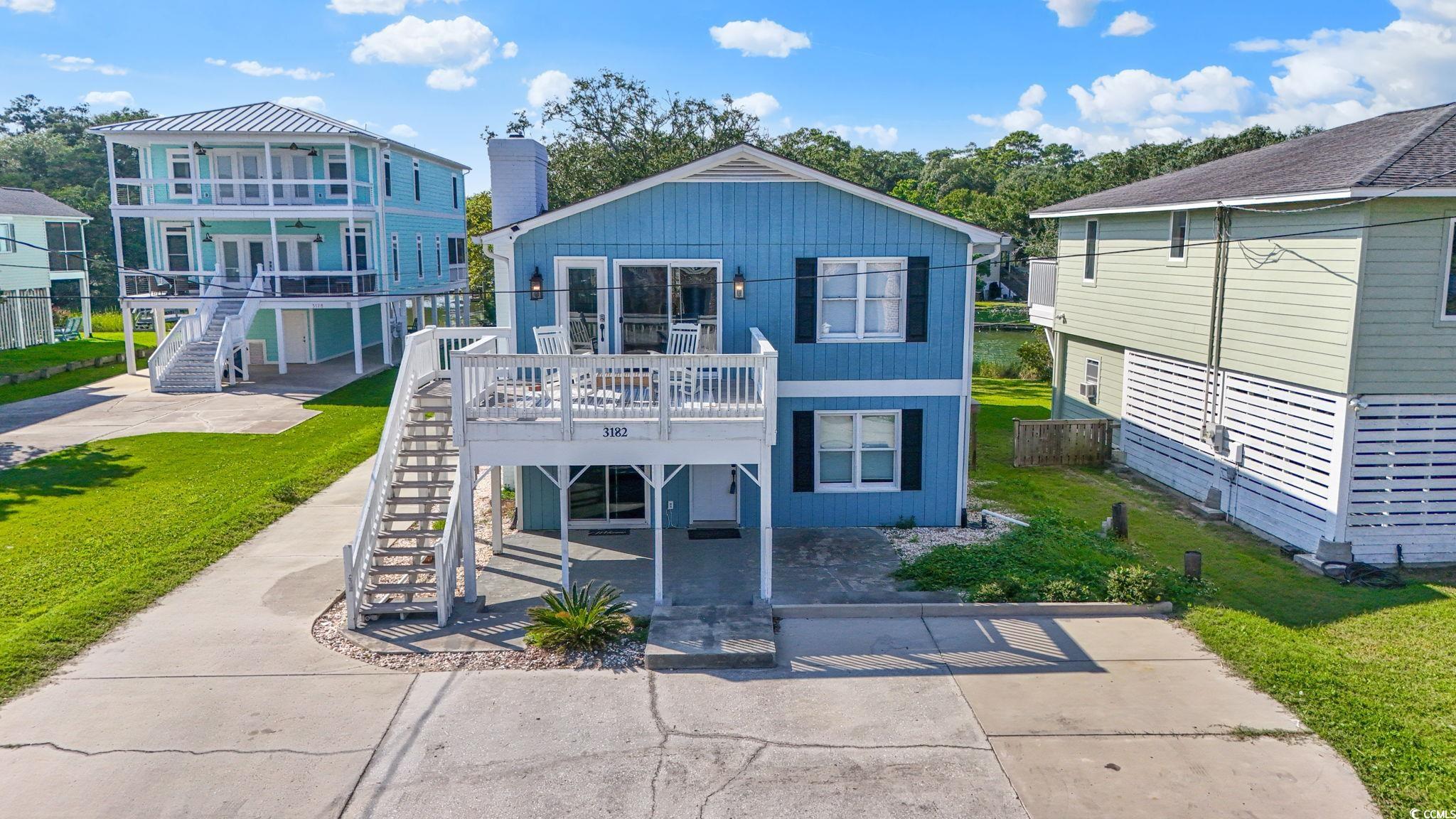 3182 State Rd S-26-816 Murrells Inlet, SC 29576 - Photo 1 of 40 View of front of property featuring stairway, a deck, concrete driveway, a patio area, and a front lawn