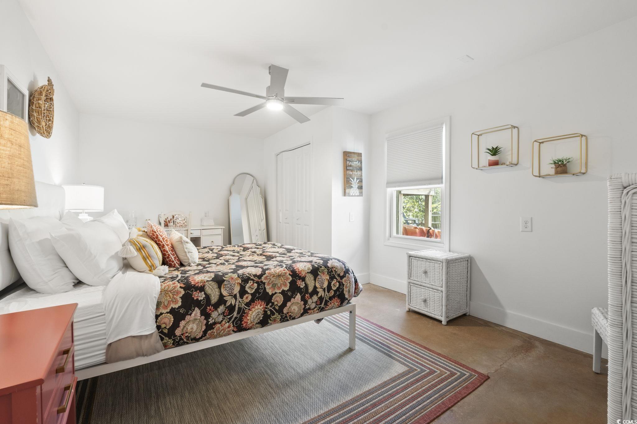 3182 State Rd S-26-816 Murrells Inlet, SC 29576 - Photo 14 of 40 Bedroom featuring finished concrete flooring, a ceiling fan, and a closet