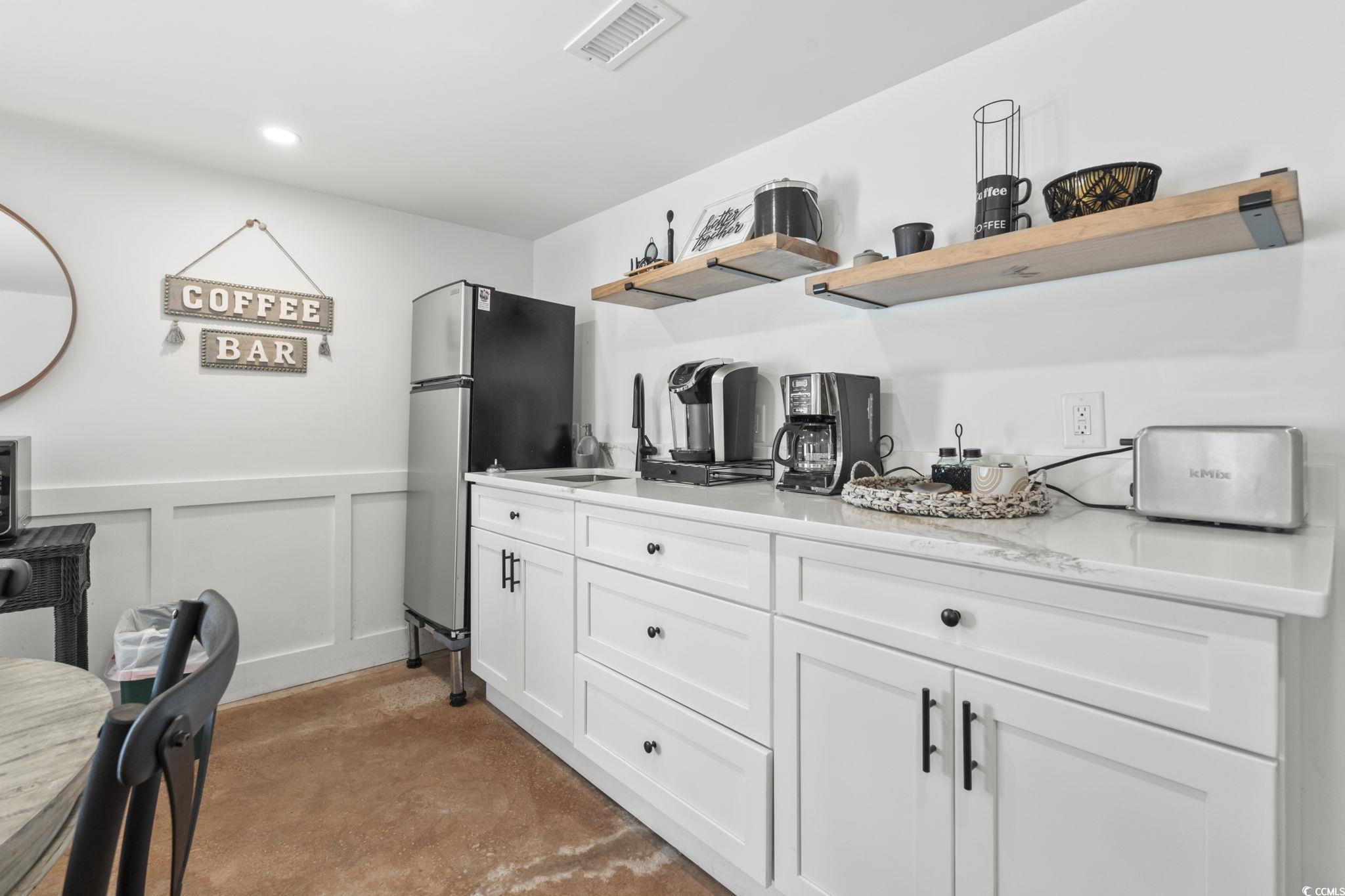 3182 State Rd S-26-816 Murrells Inlet, SC 29576 - Photo 16 of 40 Kitchen featuring white cabinets, freestanding refrigerator, carpet floors, open shelves, and wainscoting