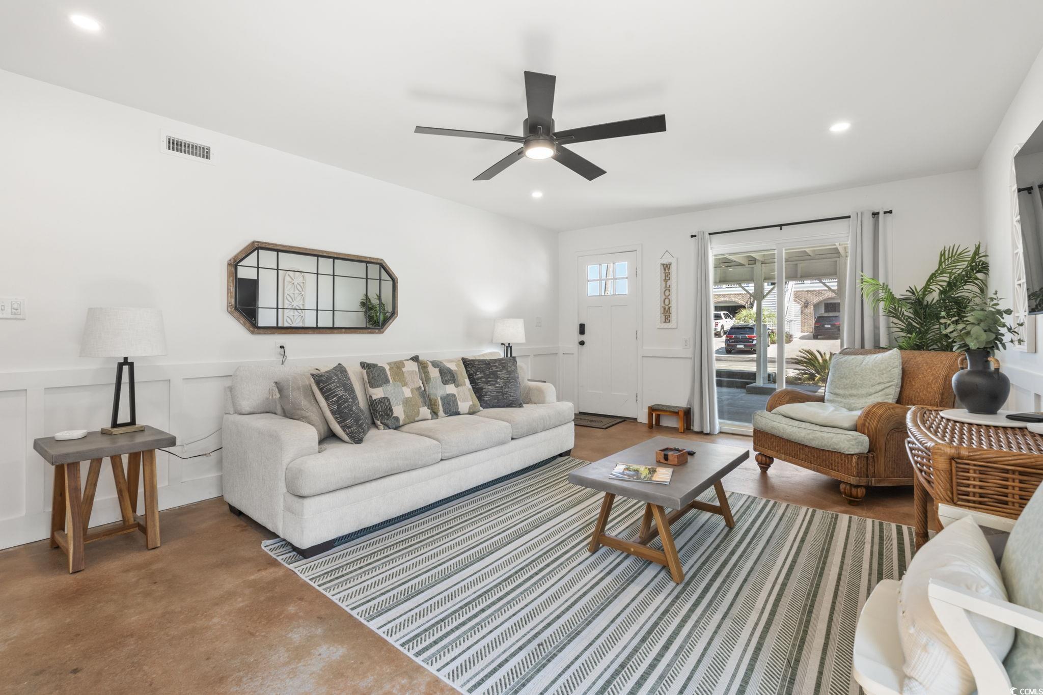 3182 State Rd S-26-816 Murrells Inlet, SC 29576 - Photo 20 of 40 Living area featuring finished concrete floors, a wainscoted wall, recessed lighting, ceiling fan, and a decorative wall