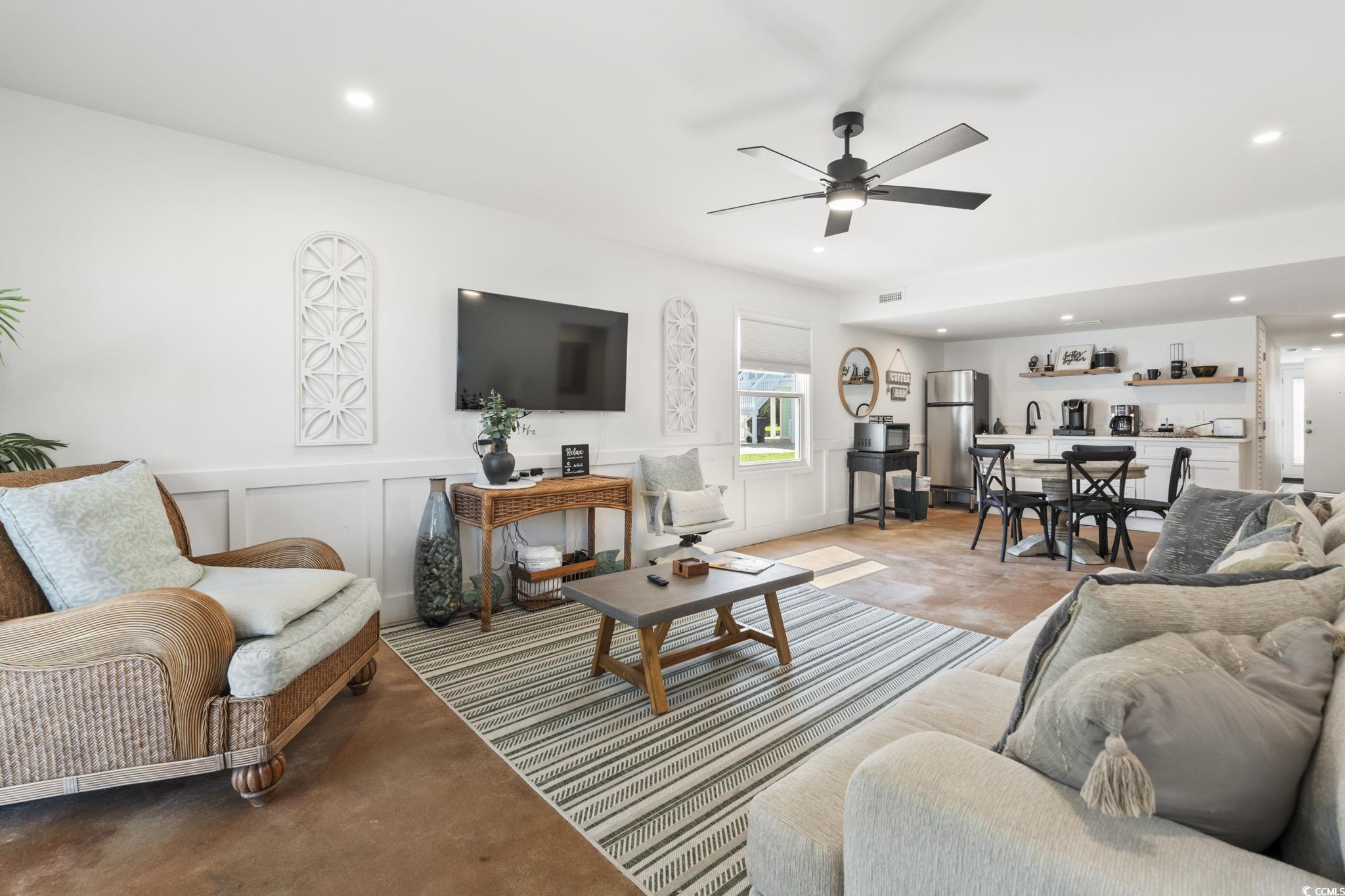 3182 State Rd S-26-816 Murrells Inlet, SC 29576 - Photo 22 of 40 Living room with a decorative wall, a wainscoted wall, recessed lighting, a ceiling fan, and concrete flooring