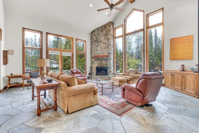 a dining hall with stainless steel appliances granite countertop a stove and white cabinets next to a large window