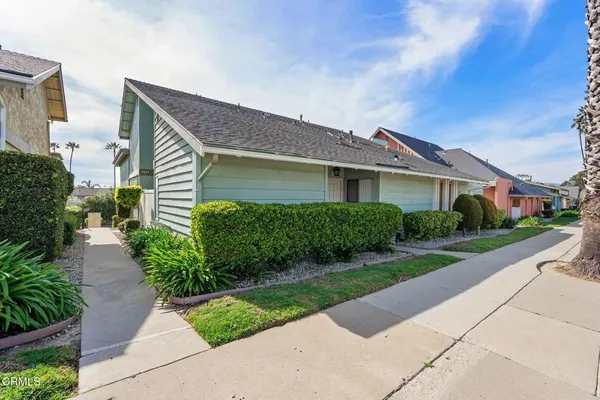 a front view of a house with a yard and potted plants