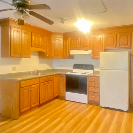 a kitchen with granite countertop a refrigerator a sink and dishwasher