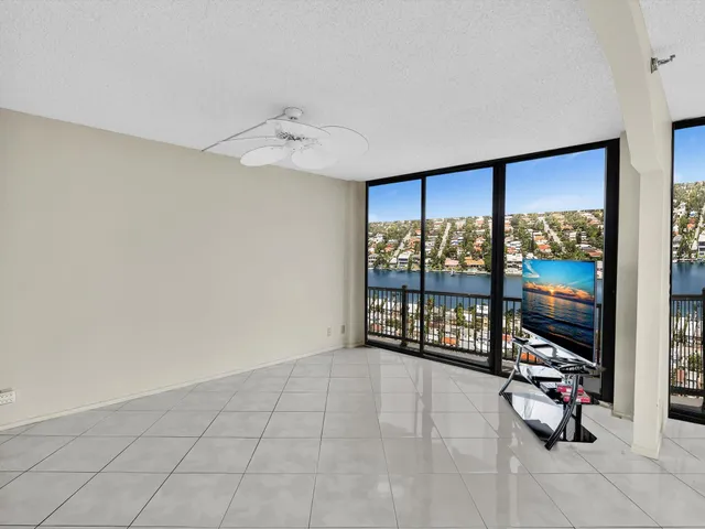 an aerial view of ocean and residential houses with outdoor space