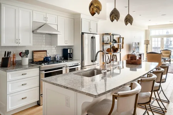 a kitchen with stainless steel appliances granite countertop a sink a stove and a refrigerator