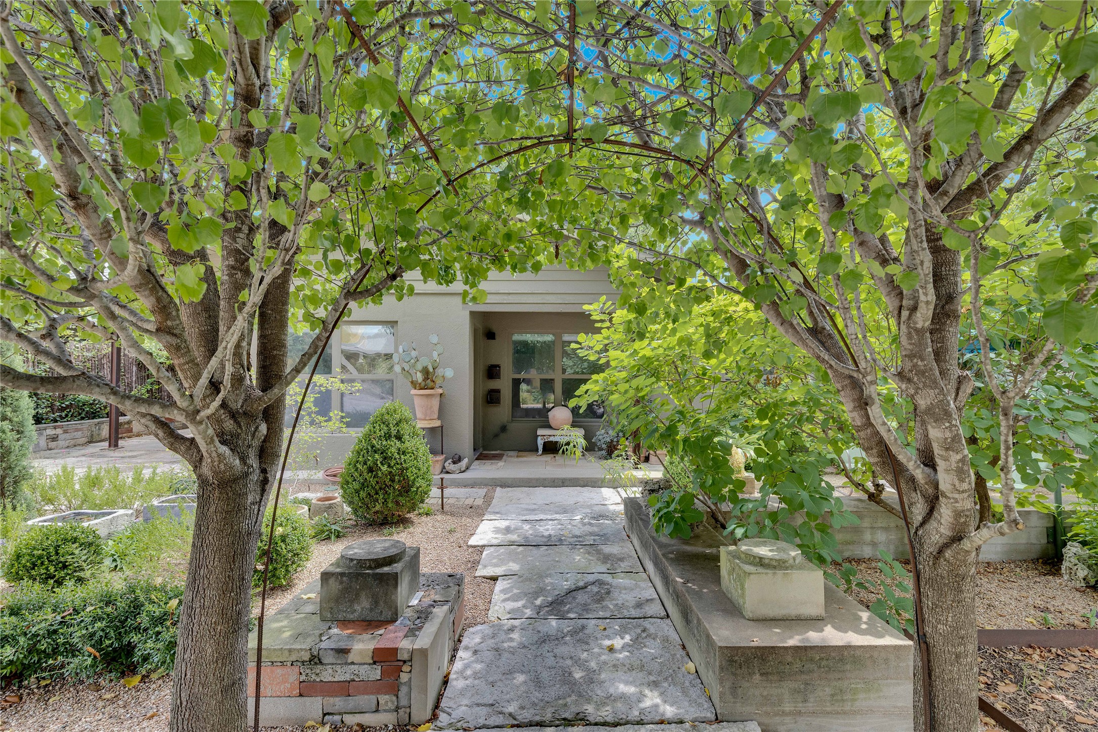 1306 Norwood Road, Unit A Austin, TX 78722 - Photo 3 of 21 A tranquil stone pathway leads through verdant Bradford Pear trees to the welcoming front entrance of this residence.