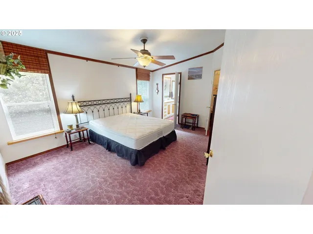 a living room with a bed furniture and a large window