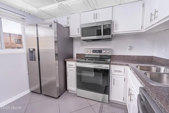 a kitchen with stainless steel appliances granite countertop a refrigerator microwave and sink