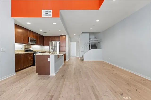 a kitchen with a sink a stove and wooden floor
