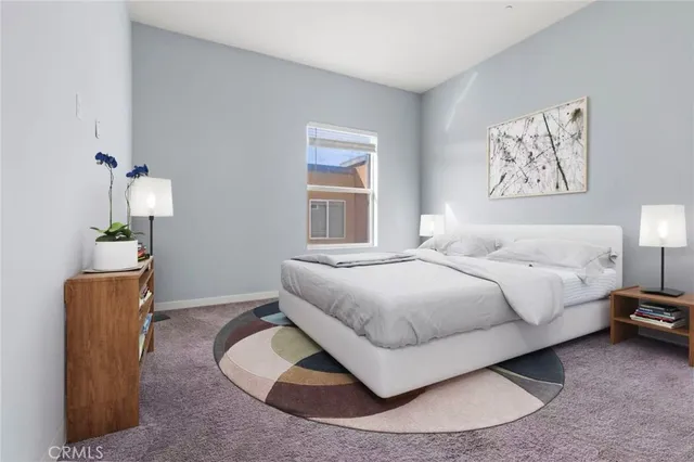 a bedroom with a bed lamp and a potted plant
