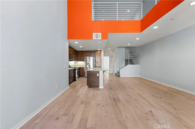 a open kitchen with kitchen island a sink dishwasher stove with wooden floors