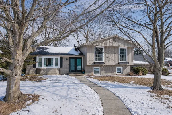 a front view of a house with a yard covered in snow