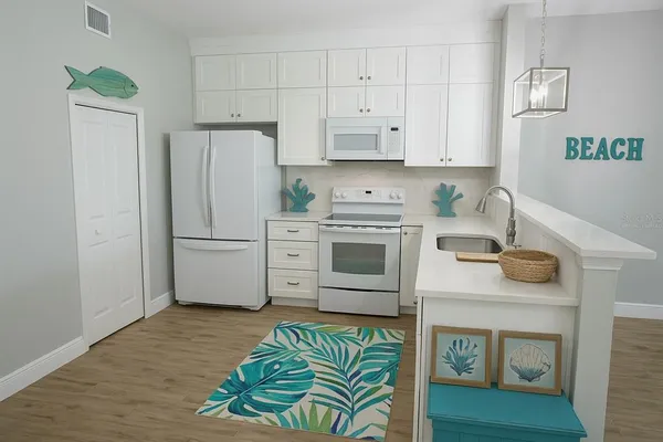 a kitchen with stainless steel appliances white cabinets and a refrigerator