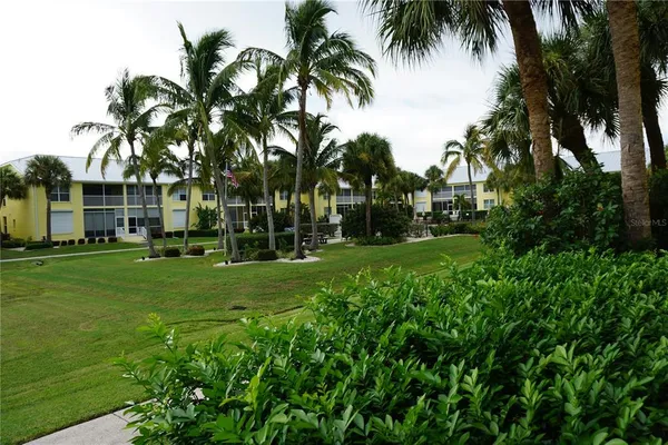 a front view of multi story residential apartment building with yard and green space