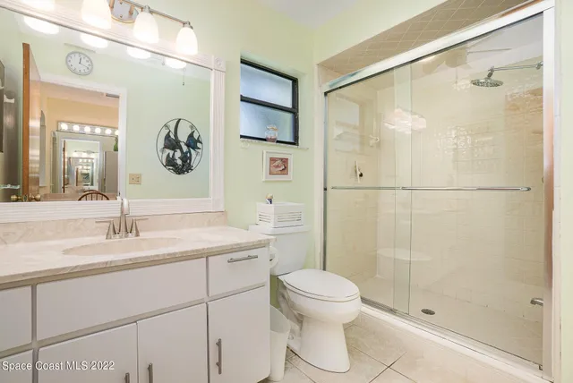 a spacious bedroom with a bed and a flat tv screen on dresser
