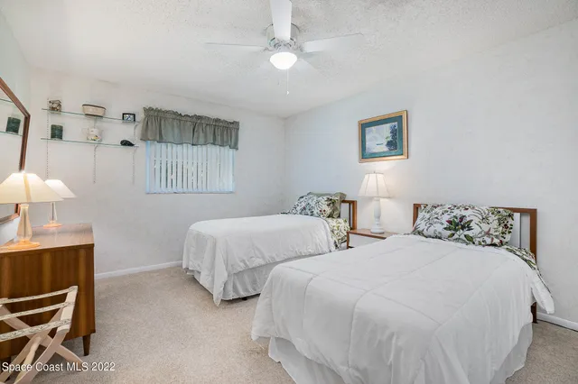 a bedroom with a bed a window and dresser