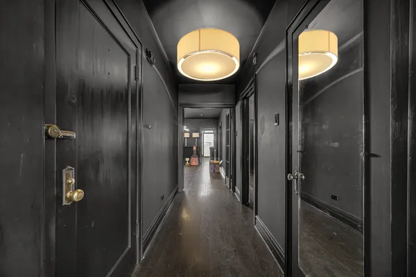 a view of a hallway with wooden floor