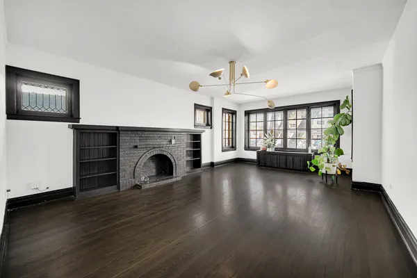 a view of a livingroom with furniture a fireplace and wooden floor