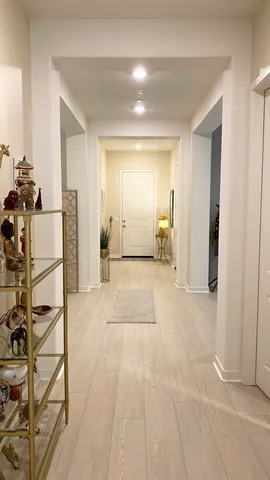 a view of a hallway with wooden floor and furniture