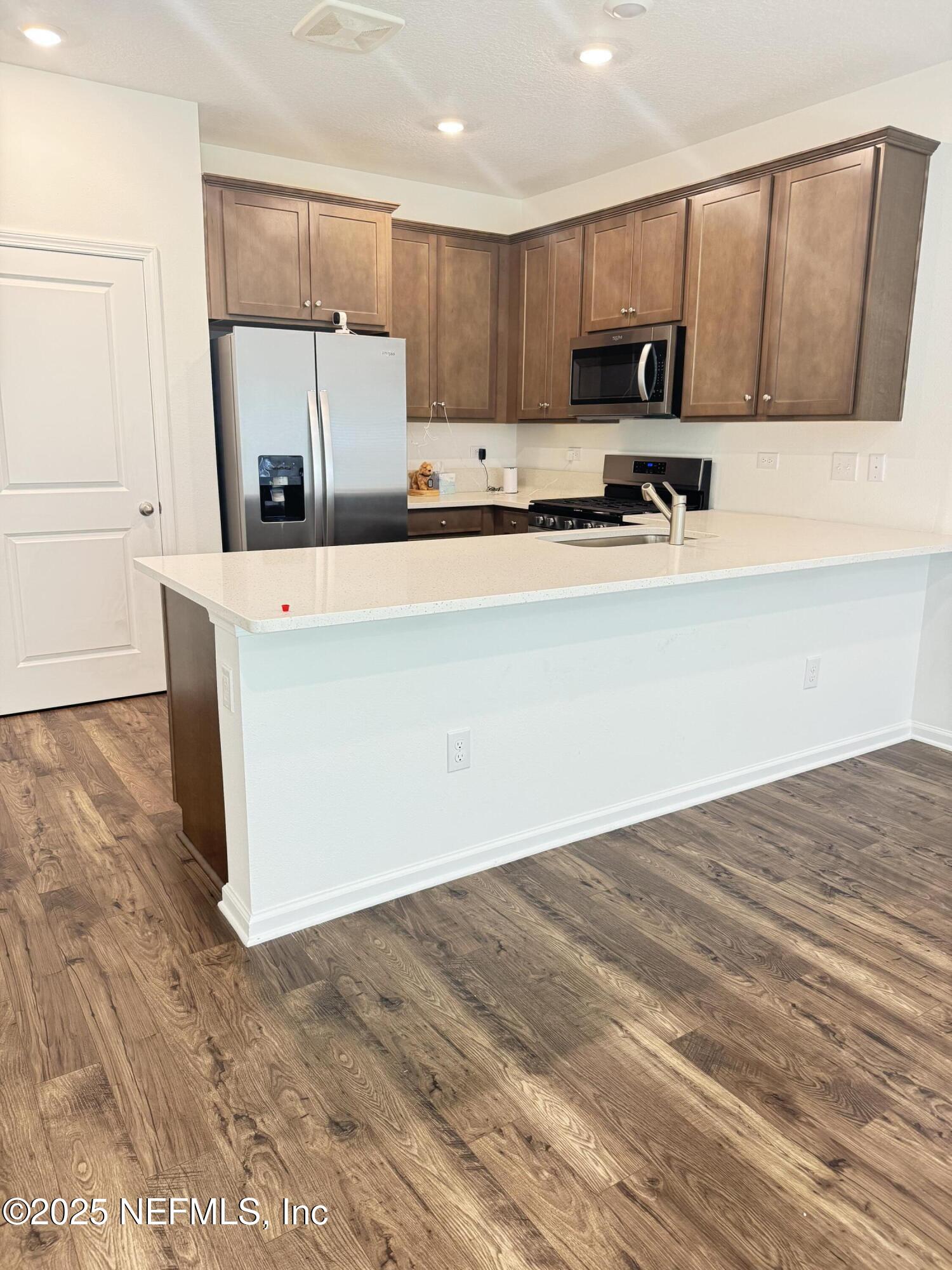 13505 Ute Jacksonville, FL 32218 - Photo 32 of 34 a kitchen with a refrigerator a stove a microwave a sink and a cabinets