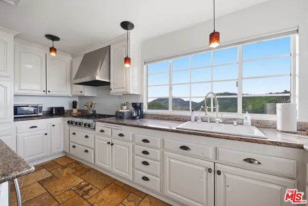 a kitchen with granite countertop white cabinets and white appliances