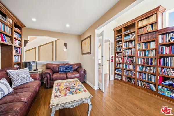 a living room with furniture and a book shelf