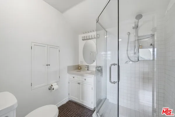 a bathroom with a granite countertop sink a toilet and shower