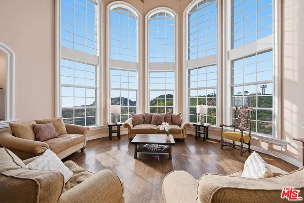 a living room with furniture and floor to ceiling windows